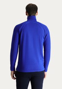 Pullover blu con collo alto, realizzato in tessuto testurizzato, dotato di maniche lunghe e una vestibilità affusolata, che presenta cuciture raglan.