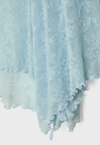 Jasnoniebieska koronka z kwiatowymi wzorami i falistymi brzegami, delikatnie ułożona na jednolitym białym tle.