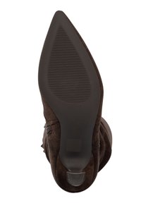 Stivale con tacco alto in pelle scamosciata marrone, con punta a punta e suola in gomma texturizzata. Il tacco è leggermente rastremato con una finitura liscia alla base.