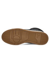 Semelle de chaussure de sport noire avec motif en caoutchouc texturé, présentant un logo circulaire et des accents ondulés de couleur beige. Construction robuste avec une bonne adhérence.