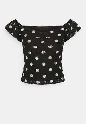 Black off-shoulder lace top with white polka dots and short puff sleeves, featuring slight ruching at the chest.