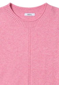 Jasnoróżowy sweter dzianinowy z prążkowanym okrągłym dekoltem, subtelną fakturą oraz szczegółowym szwem pośrodku. Metka z napisem "CECIL."