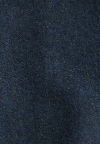 Dunkelblauer Stoff mit einer weichen, strukturierten Oberfläche, die subtile Farbvariationen und ein leicht flauschiges Aussehen aufweist.