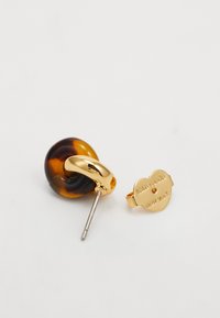 Gold-tone stud earring with tortoiseshell resin hoop and gold back engraved with "kate spade new york" on white background.