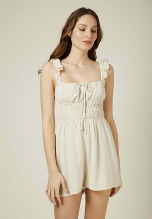 Combinaison en lin beige avec des bretelles froncées, un décolleté carré et une taille élastique. À l'avant, elle présente un détail à cordon et un design ample.