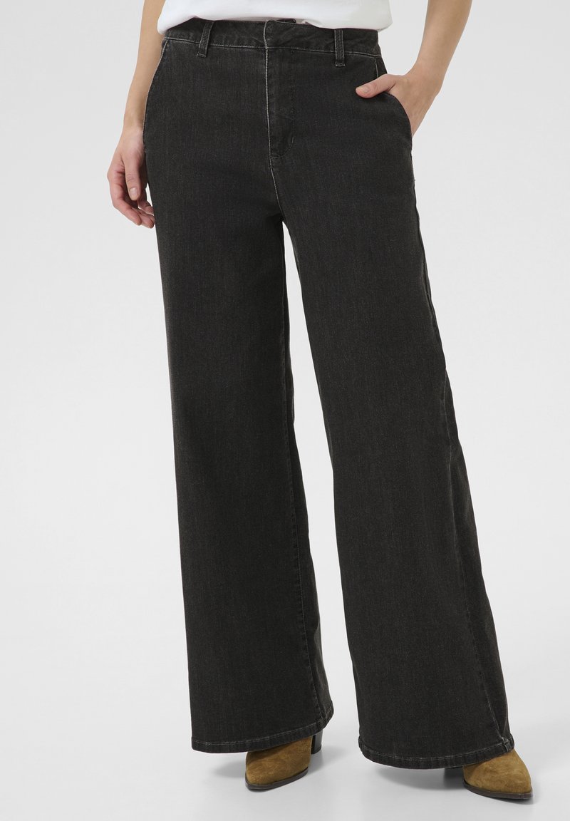 Črne široke kavbojke z visokim pasom, narejene iz denima, z sprednjimi žepi in zadrgo. Tkanina ima rahlo teksturo.