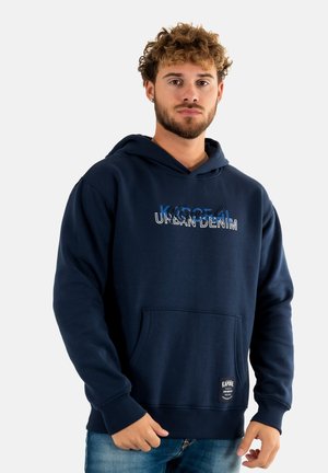 Sudadera azul marino de algodón, con un bolsillo tipo canguro, puños acanalados y texto de logo en diferentes colores en la parte frontal.