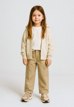 Beige Zip-up-Hoodie, weißes T-Shirt, khakifarbene Cargo-Hosen mit großen Taschen und bunte Sneaker mit strukturierten Sohlen. Leger outfit für Kinder.