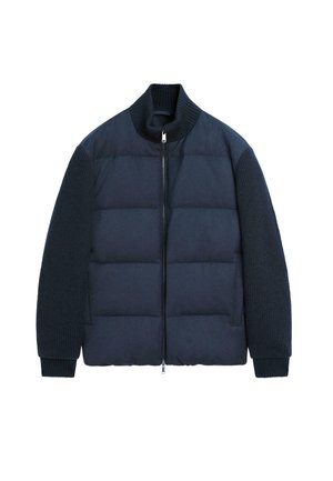 Tmavě modrá péřová bunda s žebrovanými pletenými rukávy, vysokým límcem a předním zipem, položená na bílém pozadí.