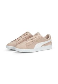 Puma lenkkarit pehmeässä vaaleanpunaisessa mokassa, joissa on valkoisia yksityiskohtia ja nauhat. Varustettu tekstuuripohjalla, jossa on uritusta ja hienovarainen logo-yleiskuva.