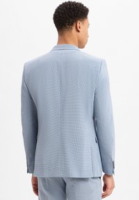 Lichtblauwe blazer met een gestructureerd patroon, getailleerde pasvorm, notch-lapels en een enkele split aan de achterkant. Heeft twee knopen en subtiele stiksels.