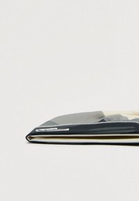 Mala para portátil com fecho, apresentando um exterior liso e preto com um interior em bege claro. Tem um padrão subtil e uma bainha ao longo das bordas.