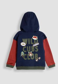 Kaputsega särk, millel on tumesinine keha ja tumepunased varrukad. Omab tikitud "WILD CUBS CLUB" teksti, loomaplekkide ja puude graafikat.