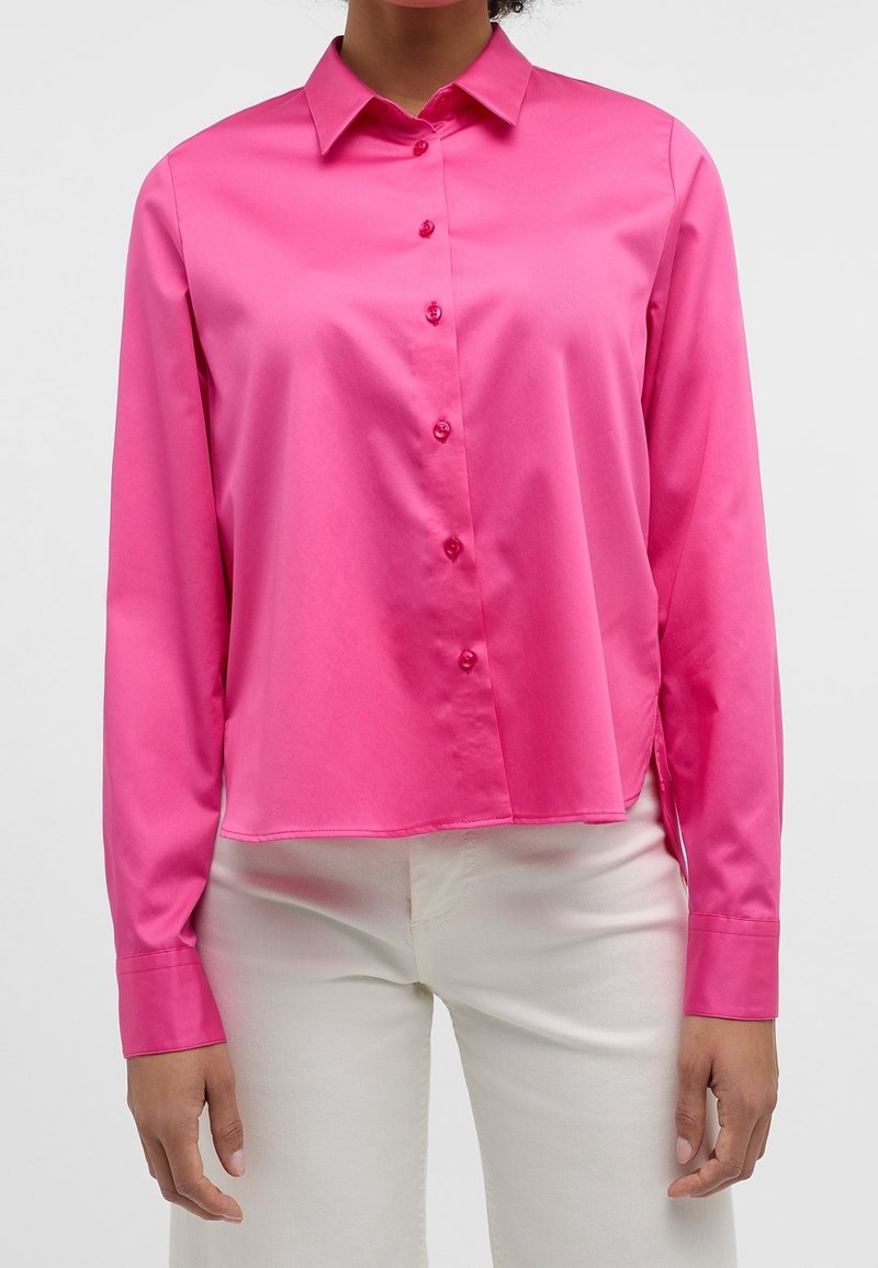 Bright pink long-sleeve button-up shirt with a collar, made of smooth fabric, featuring front buttons and a slightly curved hemline.