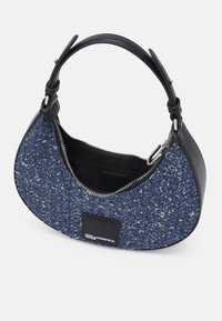 Kabelka v džínovém odstínu s texturovaným látkovým povrchem, černými koženými detaily, zakřiveným tvarem a stříbrným zipem.