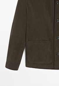 Bruine button-up shirtjack gemaakt van textuurstof. Beschikt over een zak en een rechte snit met een kraag en lange mouwen.