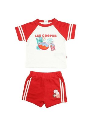 T-shirt à manches courtes rouge et blanche avec des imprimés graphiques et des rayures blanches sur les manches, assortie à un short rouge avec des rayures sur les côtés et des écussons.