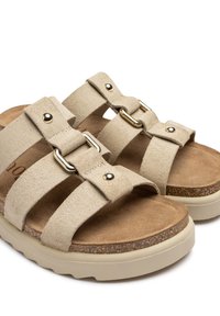 Sandalias de ante beige que cuentan con dos correas anchas con herrajes dorados, plantilla de corcho y una suela texturizada beige para mayor agarre y confort.
