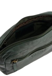 Grüne Lederhandtasche mit strukturiertem Finish, ausgestattet mit einem Reißverschluss, Innenfutter in Braun und geprägtem Markenlabel.