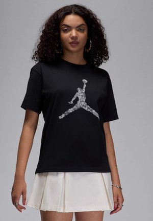 T-shirt in cotone nero con una grafica argentata del logo Jumpman. Maniche corte, vestibilità comoda, senza ulteriori motivi o decorazioni.