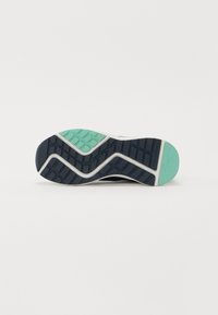 Semelle de chaussure au design ondulé. Principalement bleu marine avec des motifs de grip texturés. Accents vert menthe au talon et au bord de la semelle intermédiaire.