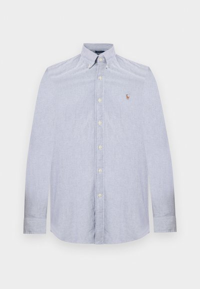 Ανοιχτό μπλε πουκάμισο με μακριά μανίκια, κουμπιά στο μπροστινό μέρος και γιακά με κουμπιά, με μικρό κεντημένο λογότυπο στο αριστερό στήθος.