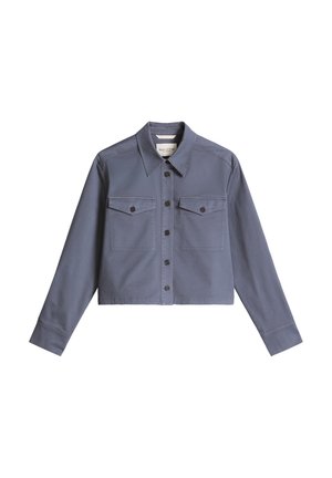 Giacca corta azzurra in cotone con chiusura frontale con bottoni, due tasche sul petto e maniche lunghe. Presenta bottoni scuri e una texture liscia.