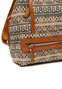 Sac en tissu texturé avec un motif géométrique multicolore comprenant des accents beige, rouge et bleu. Garniture en cuir marron et détail de poche zippée.