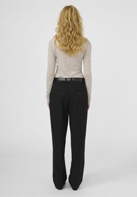 Pantaloni negri cu un design drept, dotati cu două buzunare la spate și o curea netedă. Partea de sus este o cămașă bej deschis cu mâneci lungi.