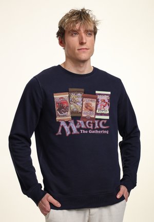Námořnická mikina s potiskem barevných balíčků karet Magic: The Gathering a logem, s kulatým výstřihem a dlouhými rukávy.