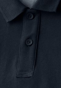 Mörkblå polo skjorta med texturerad stickning, tre svarta knappar och en klassisk krage. Sömmar synliga längs kanten av kragen.