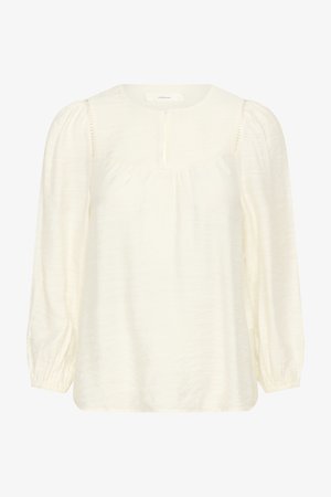 Krẹmas krāsas blūze ar garām piedurknēm, savākti plecu gabali, apaļa kakla izgriezums, viegli uzpufotas plecas un elastīgas aproces.