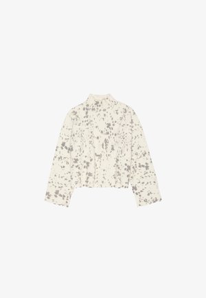 Lühendatud sviiter kõrge kaelusega, valmistatud tekstureeritud kreemjast kangast, millel on halli täpikujulise mustriga ja pikad varrukad.