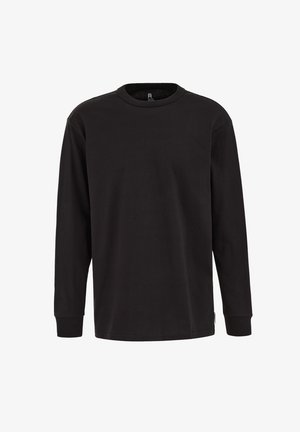 Camiseta negra de manga larga hecha de algodón. Cuenta con un cuello redondo y puños acanalados. Corte clásico con una textura suave. Sin estampados.