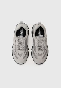 Gray athletic shoes featuring a mix of suede and mesh, with a textured surface, thick black sole, and lace-up front.