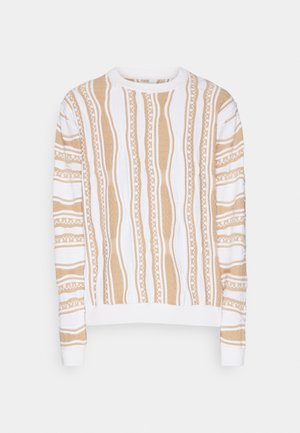 Krämsvits med vertikala beige ränder, med strukturerade mönster och vita detaljer. Ribbad halsringning och ärmslut. Mjukt tyg.