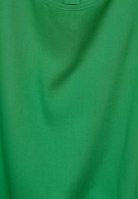 T-shirt en coton vert avec une texture lisse et un col ras du cou classique, sans motifs ni embellissements visibles.