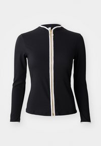 Black long-sleeve top made of ribbed fabric, featuring a white zip closure with a gold zipper and round pull tab, high collar.