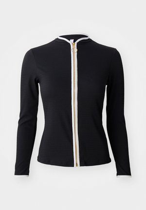 Black long-sleeve top made of ribbed fabric, featuring a white zip closure with a gold zipper and round pull tab, high collar.