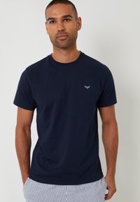 T-shirt a girocollo blu navy in cotone con maniche corte e un piccolo design ricamato sul lato sinistro del petto. Texture liscia.