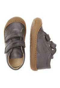 Zapatos infantiles de cuero gris con suelas de goma marrón, que cuentan con dos correas de velcro ajustables, puntera redondeada y acabado suave.