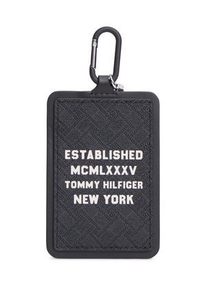 Sort tekstureret rektangulær nøglering med hvid tekst, der lyder "Established MCMLXXXV Tommy Hilfiger New York" og en sort karabinhage.