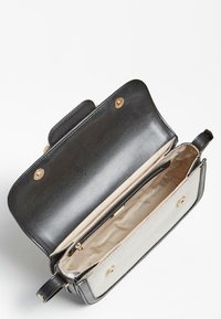 Sort lædertaske med lyst indre, der har et rum med lynlås og hardware i guldfarve. Det åbne design viser det rummelige indre.