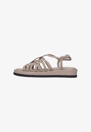 Beige flad sandal med flettede remme, ankelspænde og sort sål, vist i sideprofil på hvid baggrund.