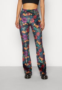 Flared broeken in een levendige bloemenprint met verschillende kleuren, waaronder paars, oranje en groen. Gemaakt van zachte stof met een elastische tailleband.