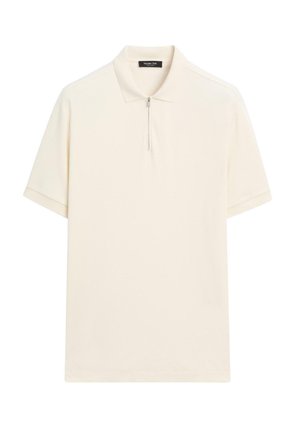 Polo à manches courtes en tissu crème, avec col zippé, coupe ample et détails de couture minimalistes. Texture lisse.