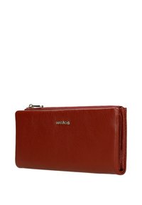 Portafoglio in pelle rossa con finitura testurizzata, dotato di chiusura a cerniera e logo metallico sulla parte frontale. Forma rettangolare compatta.