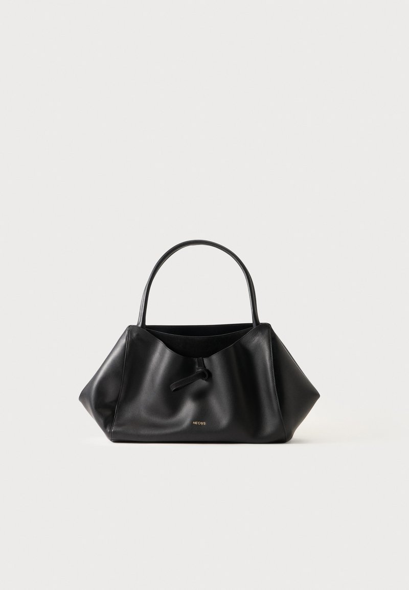 Sac à main en cuir noir avec une seule poignée supérieure et un détail de nœud au centre, sur un fond clair uni.