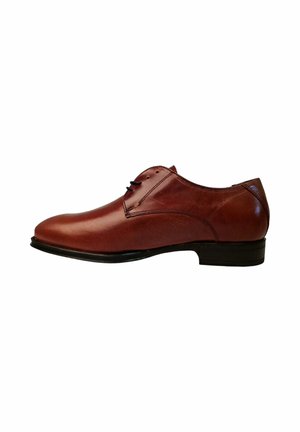 Zapato de vestir de piel marrón con un acabado suave, punta redondeada, cordones negros finos y un tacón negro bajo. Diseño simple y clásico.