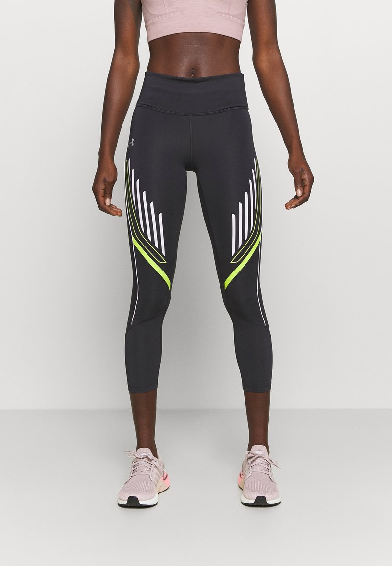 Svarta sportleggings med hög midja, med vita och neon gula diagonala ränder längs sidorna. Slät, elastisk tyg.